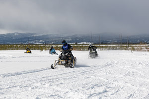 Snowmobilers riding on the trail