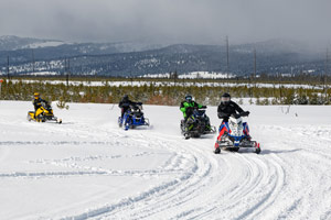 Snowmobilers riding on the trail