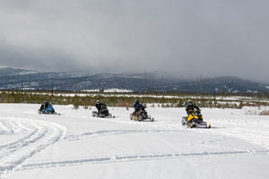 Snowmobilers riding on the trail