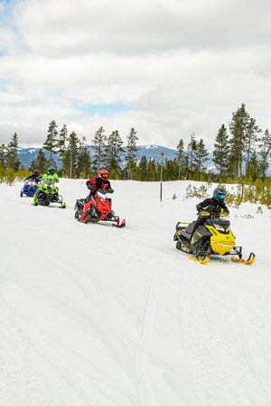 Snowmobilers riding on the trail