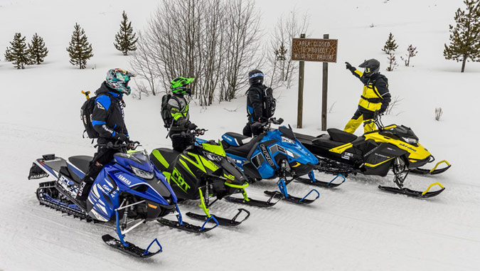 Snowmobilers reading access sign