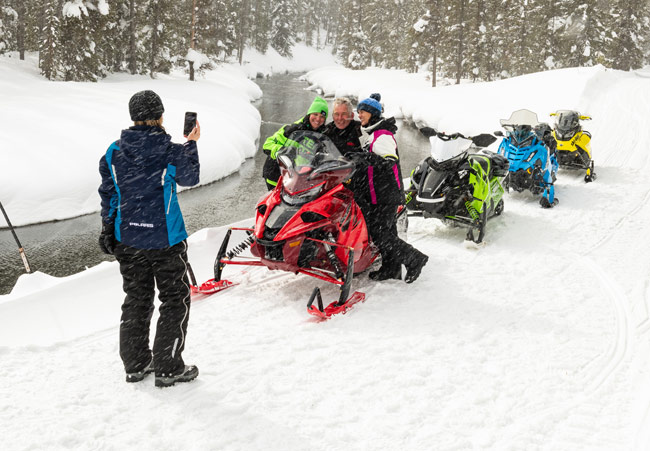 Snowmobilers reading access sign